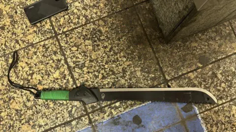 Supplied/NYPD A black machete lies on the train platform.