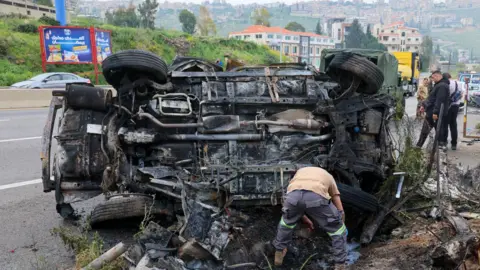 EPA Rescuers work at the site of an Israeli air strike that targeted a vehicle in Jiyeh, south of Beirut, Lebanon (15 April 2026)