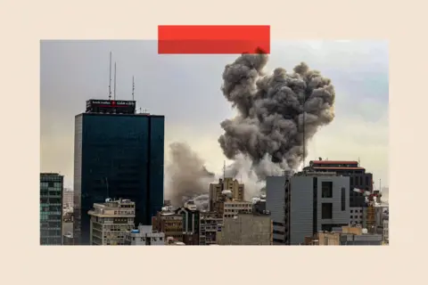 Getty Images A general view of Tehran with smoke visible in the distance after explosions were reported in the city 