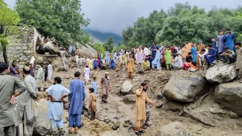 AFP via Getty Images People gathered at the site of a flash flood in Salarzai Tehsil of Pakistan's Bajaur district on August 15, 2025.