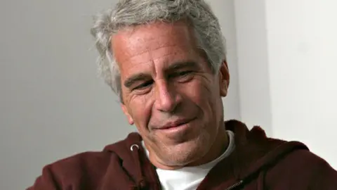 Getty Images Billionaire Jeffrey Epstein wears a brown hooded sweatshirt that says Harvard while in Cambridge, Massachusetts in 2004.