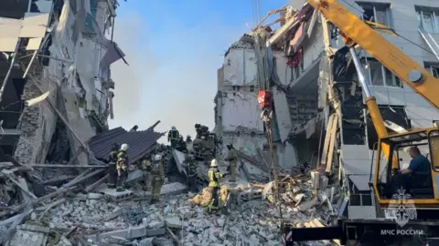 Reuters Rescuers work amid debris of a destroyed building in the Russian-occupied town of Starobilsk of eastern Ukraine. Photo: 22 May 2026
