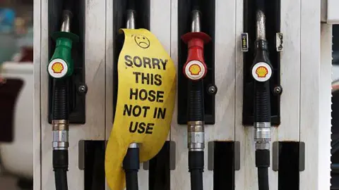 Getty Petrol dispensers at a petrol station. One has a sign reading