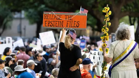 Getty Images A woman holds a sign at a protest saying 