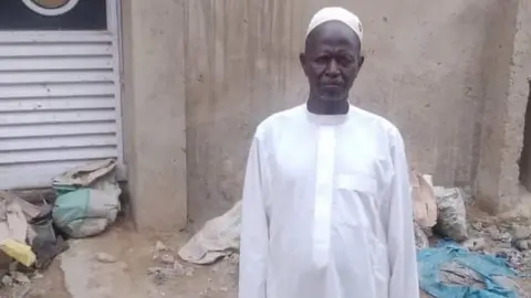Mahmud Bashir A Nigerian local chief Musa Abdullahi wearing a traditional white gown and a cap