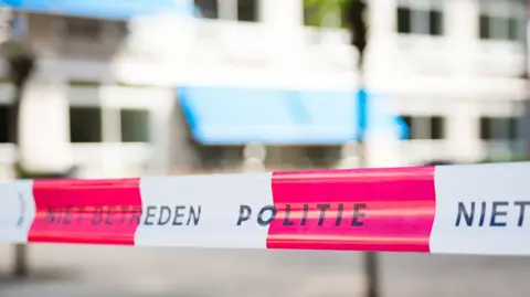 Getty Images A stock image of white-and-red striped Dutch police tape, which reads 'Politie'.