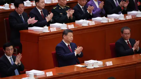EPA Xi Jinping (C), Premier Li Qiang (R) and Wang Huning (L) applaud during the opening ceremony of the Fourth Session of the 14th National People's Congress of China