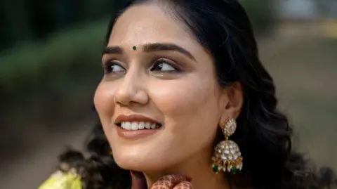 Courtesy Twisha's family A closeup photo of Twisha Sharma - she's wearing danglers and a green bindi 