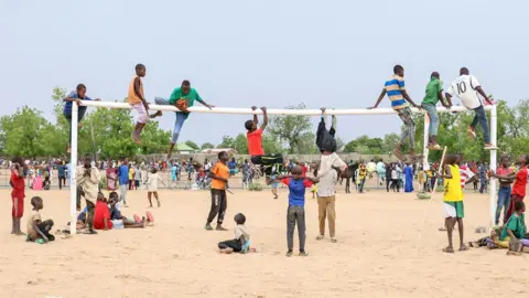 Daniel Beloumou Olomo/AFP Children climb a goal post ahead of the Cameroon International Grand Prix in Maroua, Cameroon - Saturday 11 May 2024