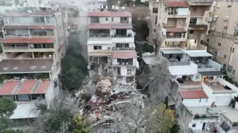 Reuters View of three large residential buildings, the central one of which has been badly damaged.