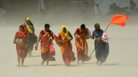 Getty Images Women facing heat wave during a hot summer day at Digha Ghat on April 12, 2026 in Patna, India.