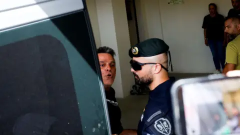 Getty Images Frenchman Marc B arriving to the Setubal courthouse on Friday being escorted by a police officer.