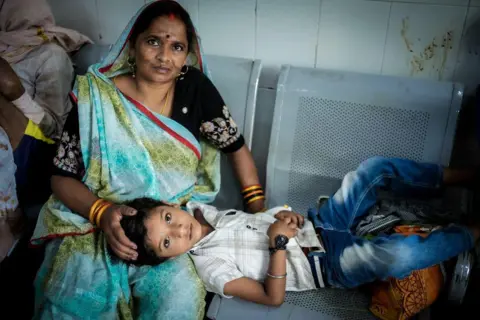 Ankit Srinivas Six-year-old Yash has spent two days being treated in a hospital corridor after falling ill during Banda's heatwave. Here he's seen laying on his mum's lap