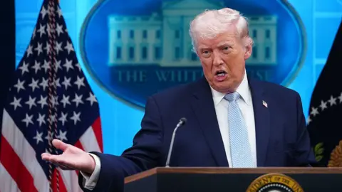 Getty Images Donald Trump speaking at the podium on 5 April. 