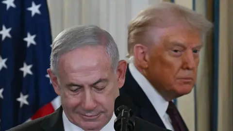 Getty Images Netanyahu and Trump at a podium in 2025. 
