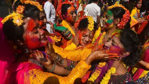 Getty Images A group of women play with colored powder during the Holi festival in Kolkata, India, on March 3, 2026.