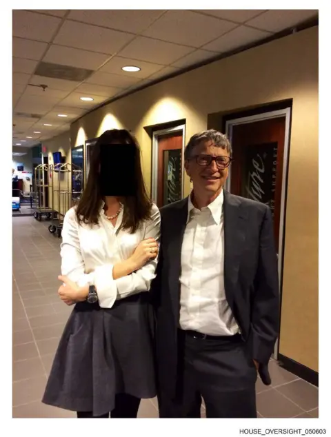 US House Oversight Committee A picture of Bill Gates with a woman whose face has been redacted. They are standing in a hallway together and posing for the photo.
