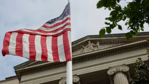 Getty Images Outside shot of the main entrance of a court . A US flag flies in front of it from a white pole. At the top of the temple-like building, in the tympanum, is a stone statue of a woman holding a sword in her left hand