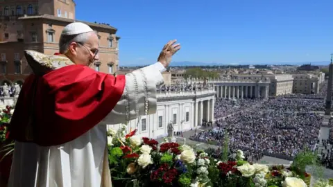 Vatican Media/Reuters Pope Leo XIV waves from the main balcony of St. Peter's Basilica