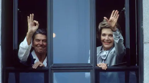 Getty Images President Ronald Reagan, recovering from cancer surgery, waves from window at Bethesda Naval Hospital, with his wife Nancy beside him