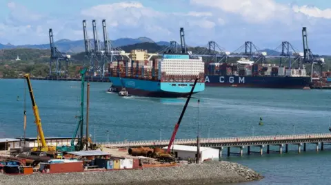 Reuters A teal coloured ship being towed into port 