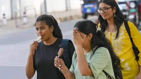 Getty Images People step out on a hot afternoon near north campus Delhi University, on April 19, 2026 in New Delhi, India.