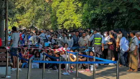 Getty Images People desperate to get visas seen outside the Thai embassy in Yangon in February