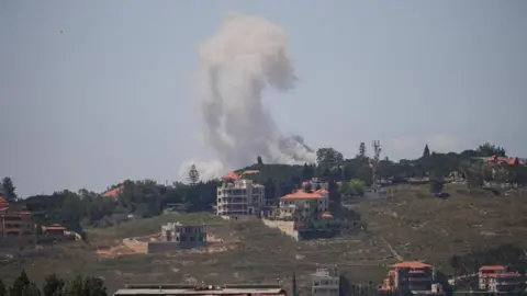 Reuters Smoke rising after a strike in southern Lebanon - several buildings are visible on the hillside 