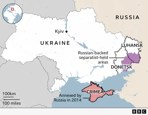 Map of Ukraine before the war, showing Ukraine and Russia. Key areas highlighted are Crimea which was wholly annexed by Russia in 2014, Luhansk and Donetsk are labelled and a large patch on the east of the two regions is shaded purple and labelled as areas held by Russian-backed separatists. The capital Kyiv is also labelled and an inset showing Ukraine's location in Europe.