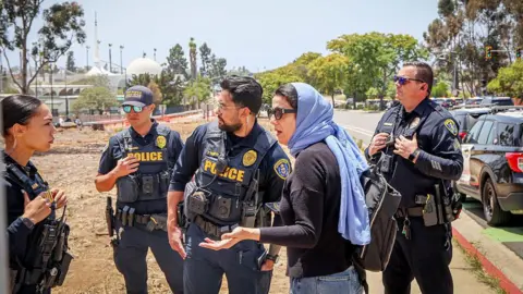 Getty Images A woman in headscarf speaks to police near the mosque