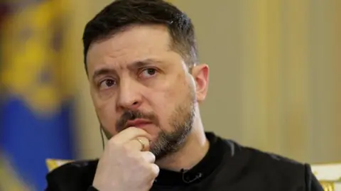 Reuters Zelensky with his hand on his chin, wearing a black top
