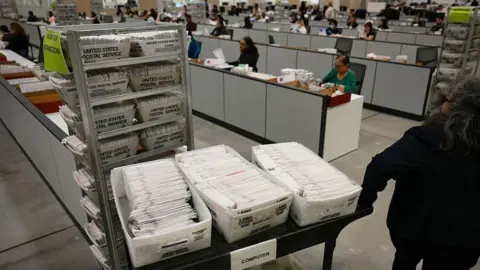 AFP An election worker moves mail-in ballots to be organised for tabulation at the Los Angeles County Ballot Processing Center during California's state primary election in the City of Industry, California, on 2 June 2026. 