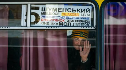 Getty Images Kherson City After The Russian Occupation During The War In Ukraine
A local of Kherson salutes from a city bus. The city now in hands of Ukraine tries to retake the normal life and services after the russian occupation during the war in Ukraine. (Photo by Celestino Arce/NurPhoto via Getty Images)