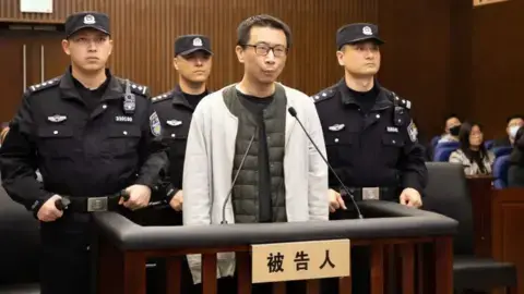 Shanghai First Intermediate People's Court Xu Yao in a white jacket in court, surrounded by guards