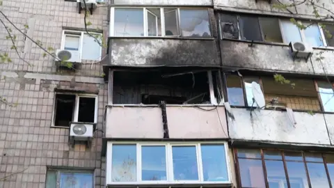 Reuters An exterior mid shot of an apartment block, showing the balcony of one apartment burned, as well as the exterior of apartments above it. 