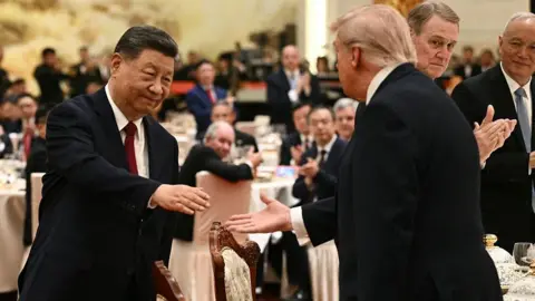 Getty Images China's President Xi Jinping (L) shakes hands with US President Donald Trump at a state banquet at the Great Hall of the People in Beijing on May 14, 2026