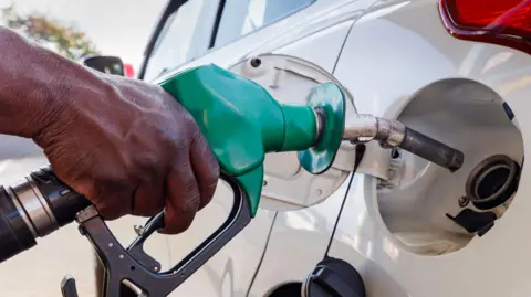 Getty Images Petrol attendant busy inserting the nozzle in the vehicle at a filling station