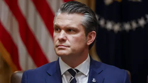 EPA Pete Hegseth, wearing a blue suit, blue and white striped neck tie and a lapel pin, during a meeting at the White House.
