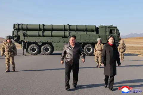 KCNA VIA KNS via AFP This picture taken on January 27, 2026 and released by North Korea's official Korean Central News Agency (KCNA) on January 28, 2026 shows North Korean leader Kim Jong Un (C) and his daughter Kim Ju Ae (2nd L) inspecting a test firing of the renewed large-caliber rocket launcher system, at an undisclosed location in North Korea.