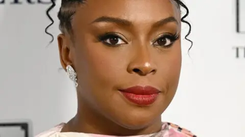Getty Images Nigerian author Chimamanda Adichie wearing a red lipstick in an event function