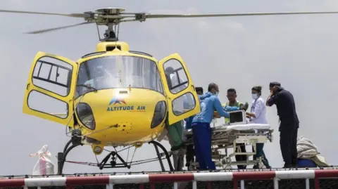 EPA Hillary Dawa being carried from a stretcher to a helicopter
