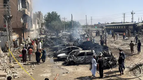 Reuters People and police officers gather after a blast near a railway track in Quetta, Pakistan