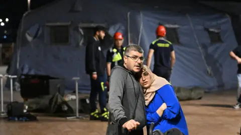 EPA Two residents of Pozzuoli outside a tent camp