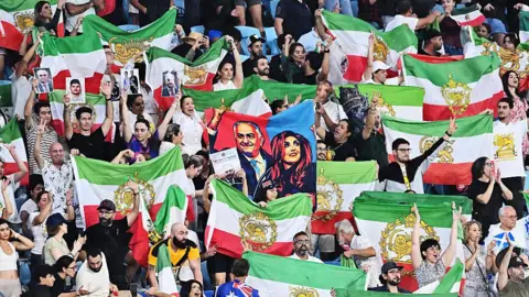 Getty Iranian supporters in the stands wave green, white and red flags