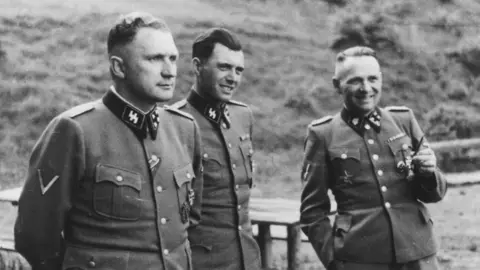 Universal History Archive Three men in Nazi SS uniform in a black and white picture