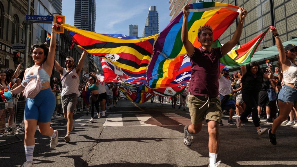 Participants run with a multinations pride flag during the Toronto Pride Parade