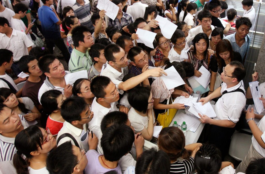 2010年中國河南省的一個工作招聘會上，應聘者蜂擁在富士康科技公司的展台前。