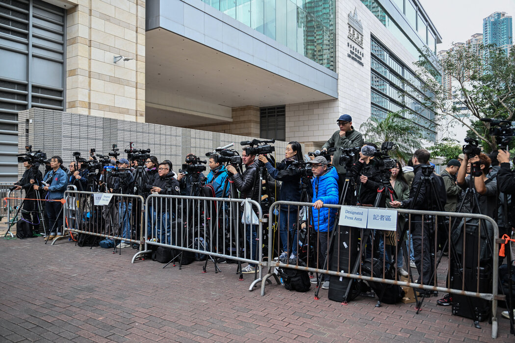 記者們聚集在香港一家法院，報導對民主派報紙《蘋果日報》創始人黎智英的審判。