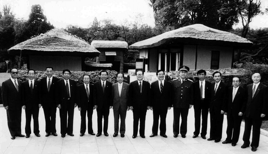 王滬寧(右四)與中國領導人江澤民(右七)在江澤民2001年9月訪問平壤期間的照片,發表於朝鮮官方媒體。