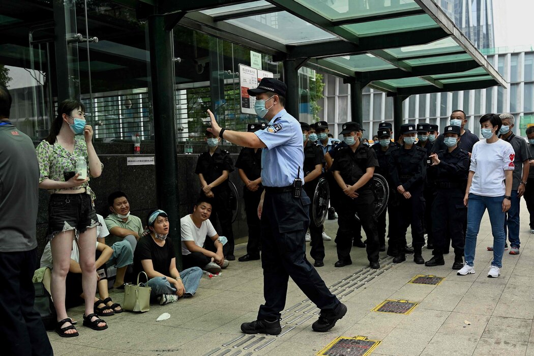 2021年,一名警察與聚集在深圳中國恆大總部外的民眾進行交涉。